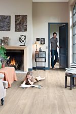 Parquet laminado de roble medio im 1856 de la marca quick-step de la serie impressive en un ambiente de habitación.