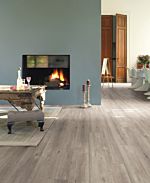Parquet laminado de roble con cortes de sierra im 1857 de la marca quick-step de la serie impressive en un ambiente de habitación.