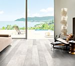 Parquet laminado de roble rústico claro LPU1396 de la marca Quick-Step de la serie LARGO en un ambiente de habitación con gente.
