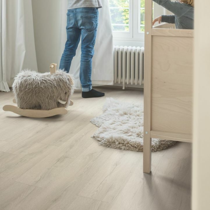 Suelo laminado de la marca Quick-step de la serie CLASSIC Roble gris intenso instalado en un dormitorio infantil.