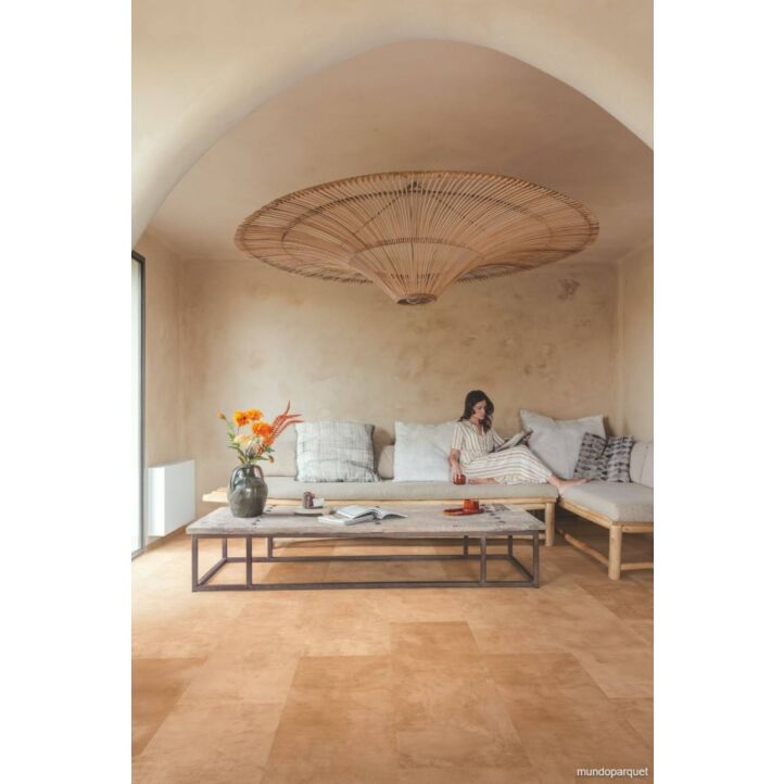 Suelo laminado de Quick-Step de la colección Muse Terracota instalado en una sala de estar con una mujer leyendo