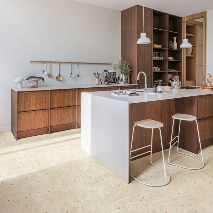 Suelo laminado de Quick-Step de la colección Muse Terracota instalado en una sala de estar con una mujer leyendo