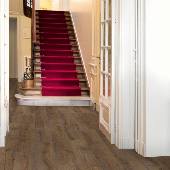 Parquet laminado de roble cambridge oscuro de la marca quick-step de la serie largo en un ambiente de habitación.