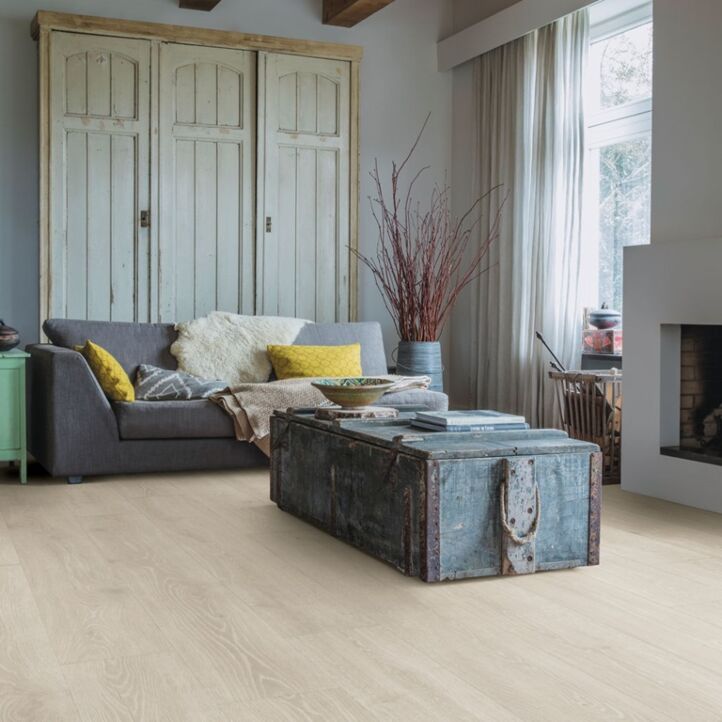 Parquet laminado de roble bosque gris claro mj3547 de la marca quick-step de la serie majestic en un ambiente de habitación.