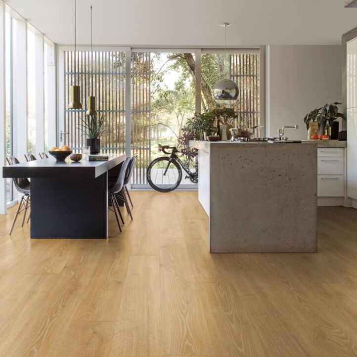 Parquet laminado de roble bosque natural mj3546 de la marca quick-step de la serie majestic en un ambiente de habitación.
