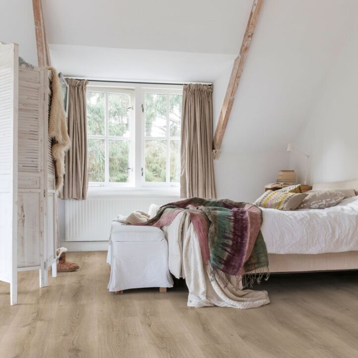 Parquet laminado de roble desierto gris cepillado de la marca quick-step de la serie majestic en un ambiente de habitación.