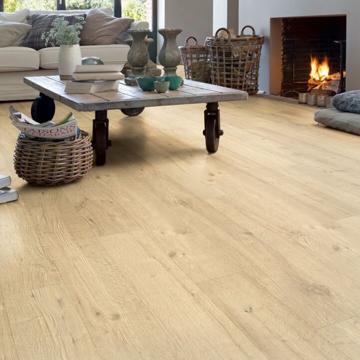 Parquet laminado de roble tratado con chorro de arena natural de la marca quick-step de la serie impressive ultra en un ambiente de habitación.