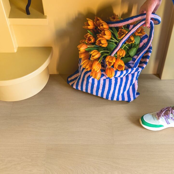 Parquet laminado de roble barnizado blanco de la marca quick-step de la serie impressive ultra en un ambiente de habitación.