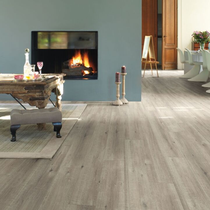 Parquet laminado de roble con cortes de sierra gris im 1858 de la marca quick-step de la serie impressive ultra en un ambiente de habitación.