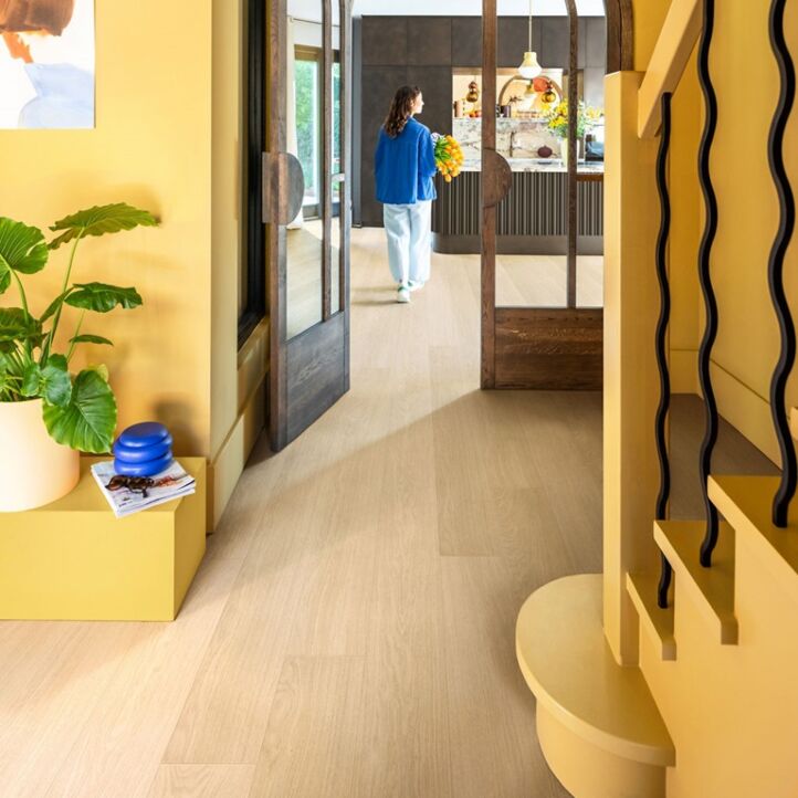 Parquet laminado de roble barnizado blanco de la marca quick-step de la serie impressive  en un ambiente de habitación.