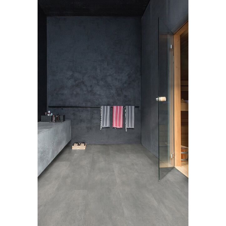 Parquet vinílico de la marca Quick-Step livyn hormigón gris oscuro AMCP40051 de la serie Ambient Click Plus en un ambiente de habitación.
