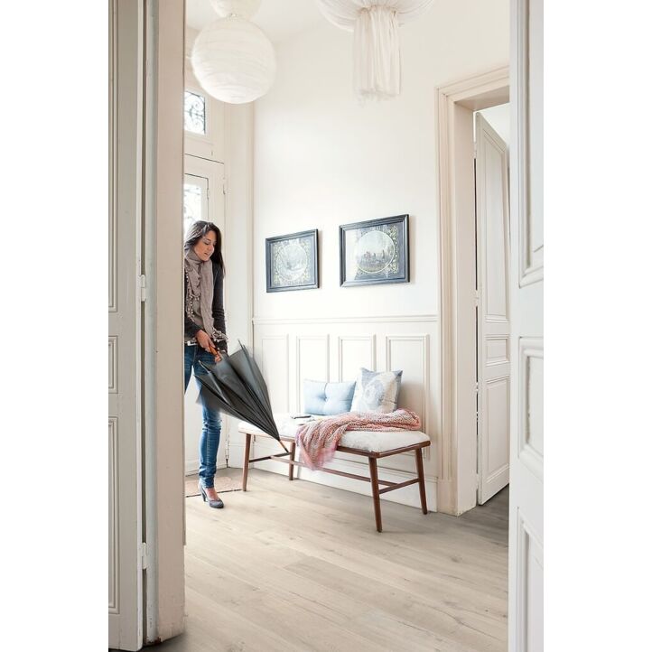 Parquet laminado de roble suave de la marca quick-step de la serie impressive en un ambiente de habitación.