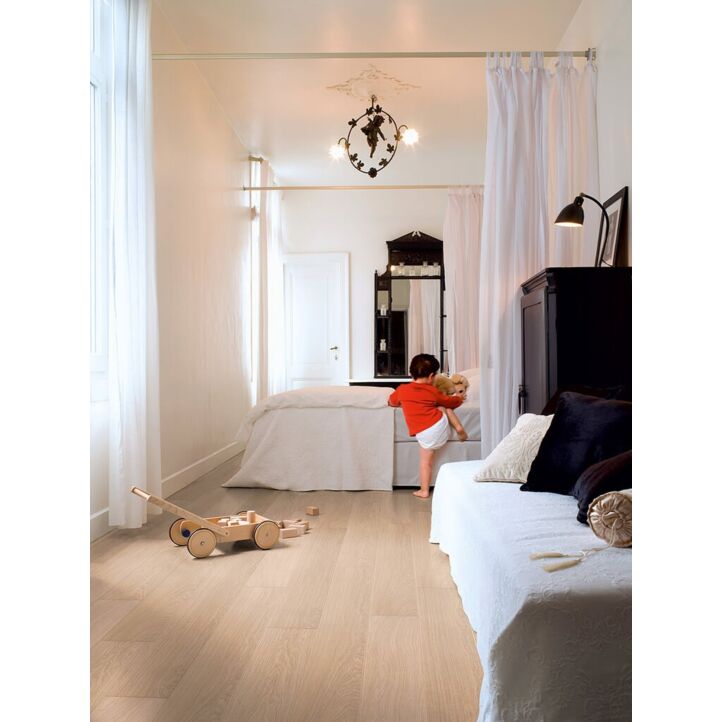 Parquet laminado de roble barnizado blanco de la marca quick-step de la serie impressive ultra en un ambiente de habitación.
