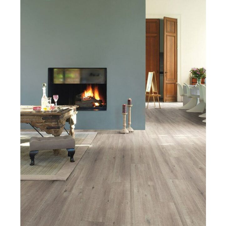 Parquet laminado de roble con cortes de sierra gris im 1858 de la marca quick-step de la serie impressive en un ambiente de habitación.