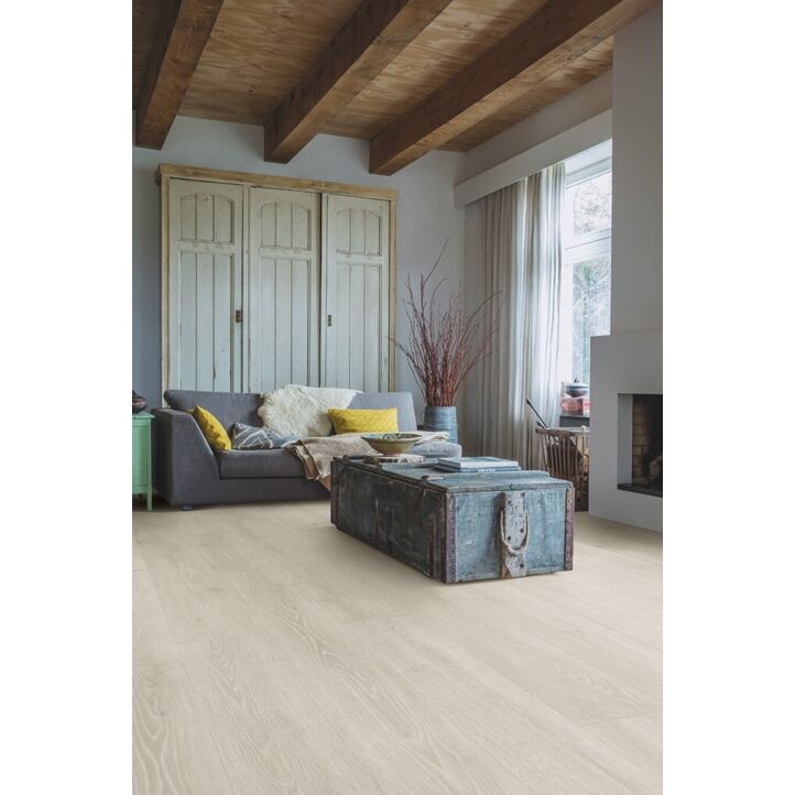 Parquet laminado de roble bosque gris claro mj3547 de la marca quick-step de la serie majestic en un ambiente de habitación.