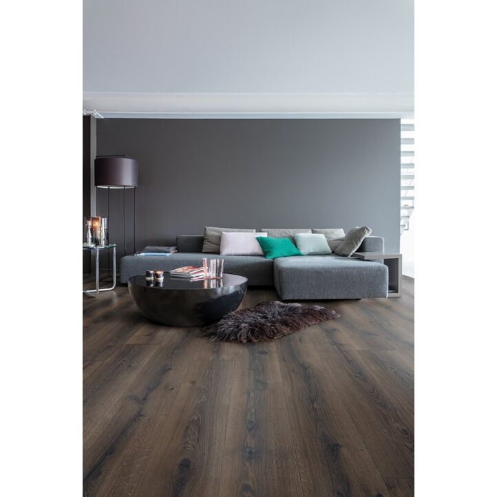 Parquet laminado de roble desierto marrón oscuro cepillado de la marca quick-step de la serie majestic en un ambiente de habitación.