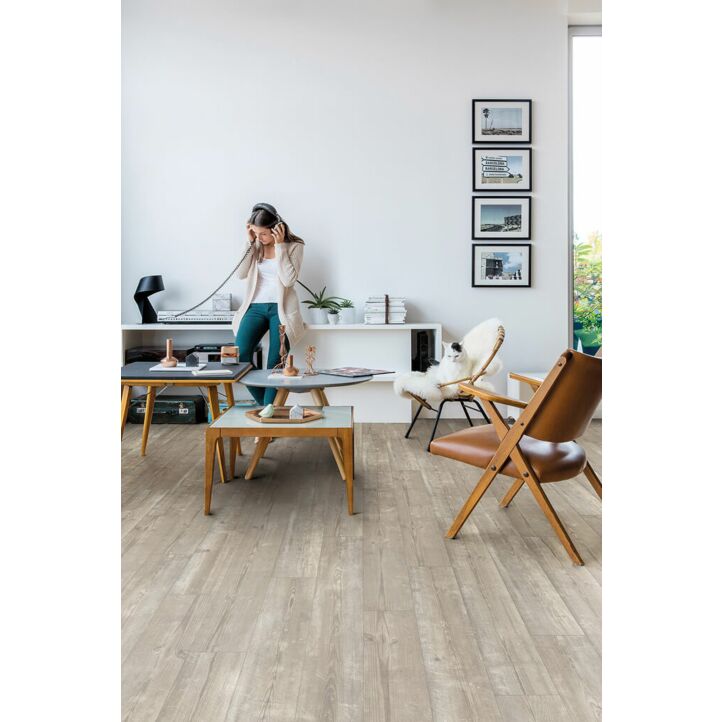 Parquet vinílico de la marca Quick-Step livyn Pino neblina matinal PUCP40074 de la serie Pulse Click plus en un ambiente de habitación con personas.