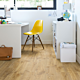 Parquet laminado de roble natural louisiana CR3176 de la marca Quick-Step de la colección CREO en un ambiente de habitación.