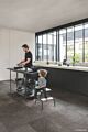Suelo laminado de Quick-Step de la colección Muse pizarra gris instalado en una cocina con un hombre cocinando y un niño mirando