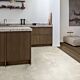 Suelo laminado de Quick-Step de la colección Muse Hormigón Moteado instalado en un ambiente de salón con un hombre leyendo y un perro visto de más cerca