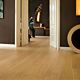 Parquet laminado de roble barnizado natural de la marca quick-step de la serie largo en un ambiente de habitación.