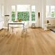 Parquet laminado de roble barnizado natural de la marca quick-step de la serie impressive ultra en un ambiente de habitación.