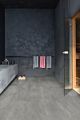 Parquet vinílico de la marca Quick-Step livyn hormigón gris oscuro AMCP40051 de la serie Ambient Click Plus en un ambiente de habitación.