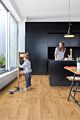 Parquet vinílico de la marca Quick-Step livyn Roble otoño natural claro PUCL40087 de la serie Pulse Click en un ambiente de habitación.