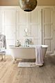 Parquet laminado de Roble clásico beige IM1847 de la marca Quick-Step de la serie Impressive en un ambiente de habitación.