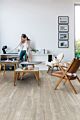 Parquet vinílico de la marca Quick-Step livyn Pino neblina matinal PUCP40074 de la serie Pulse Click plus en un ambiente de habitación con personas.