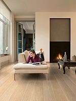 Parquet laminado de roble mañana claro UW1535 de la marca Quick-Step de la serie Eligna Wide en un ambiente de habitación.