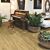 Suelo laminado de la marca Quick-step de la serie CLASSIC Roble marron miel instalado en un salon con un piano