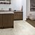 Suelo laminado de Quick-Step de la colección Muse Hormigón Moteado instalado en un ambiente de salón con un hombre leyendo y un perro visto de más cerca