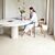 Suelo laminado de Quick-Step de la colección Muse Tiza instalado en un salón con una mujer sentada en una silla leyendo