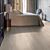 Parquet laminado de roble desierto marrón oscuro cepillado de la marca quick-step de la serie majestic en un ambiente de habitación.