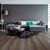 Parquet laminado de roble desierto marrón oscuro cepillado de la marca quick-step de la serie majestic en un ambiente de habitación.