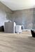 Parquet vinílico de la marca Quick-Step livyn Roble tormenta de arena gris cálido PUCL40083 de la serie Pulse Click en un ambiente de habitación.