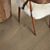 Suelo de madera multicapa de la marca pergo roble gris nordico en vista detallada con una silla