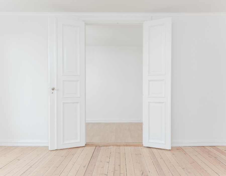 Puerta blanca con suelo claro de madera 